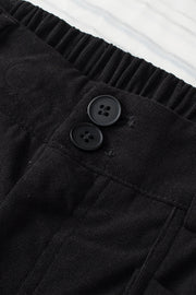 Black seamed front wide leg trousers with button detail and elastic waistband.