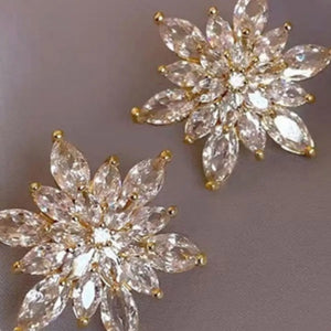 Gold 18K gold-plated stud earrings with clear marquise-cut crystals in a floral snowflake design.