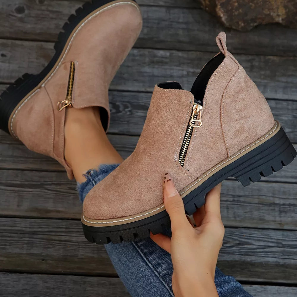 Pink suede ankle boots with side zipper and rugged sole.