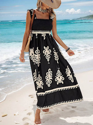 Black smocked square neck maxi dress with white ornate print and ruffled straps.