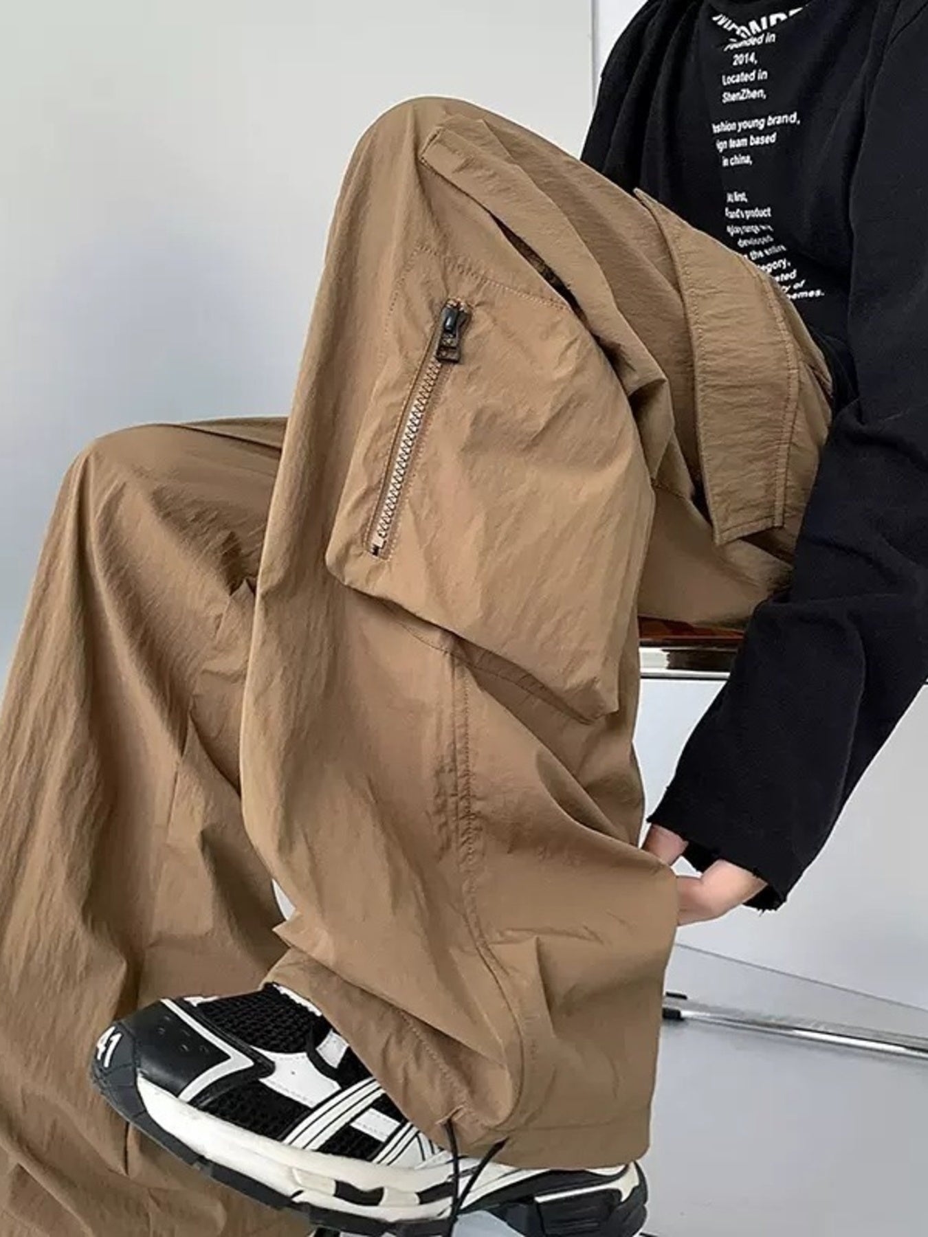 Men's camel cargo sweatpants with zippered pocket detail and drawstring.