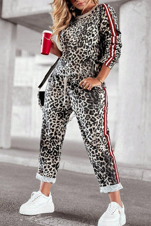 Leopard print joggers with red and white side stripes and a drawstring waist.