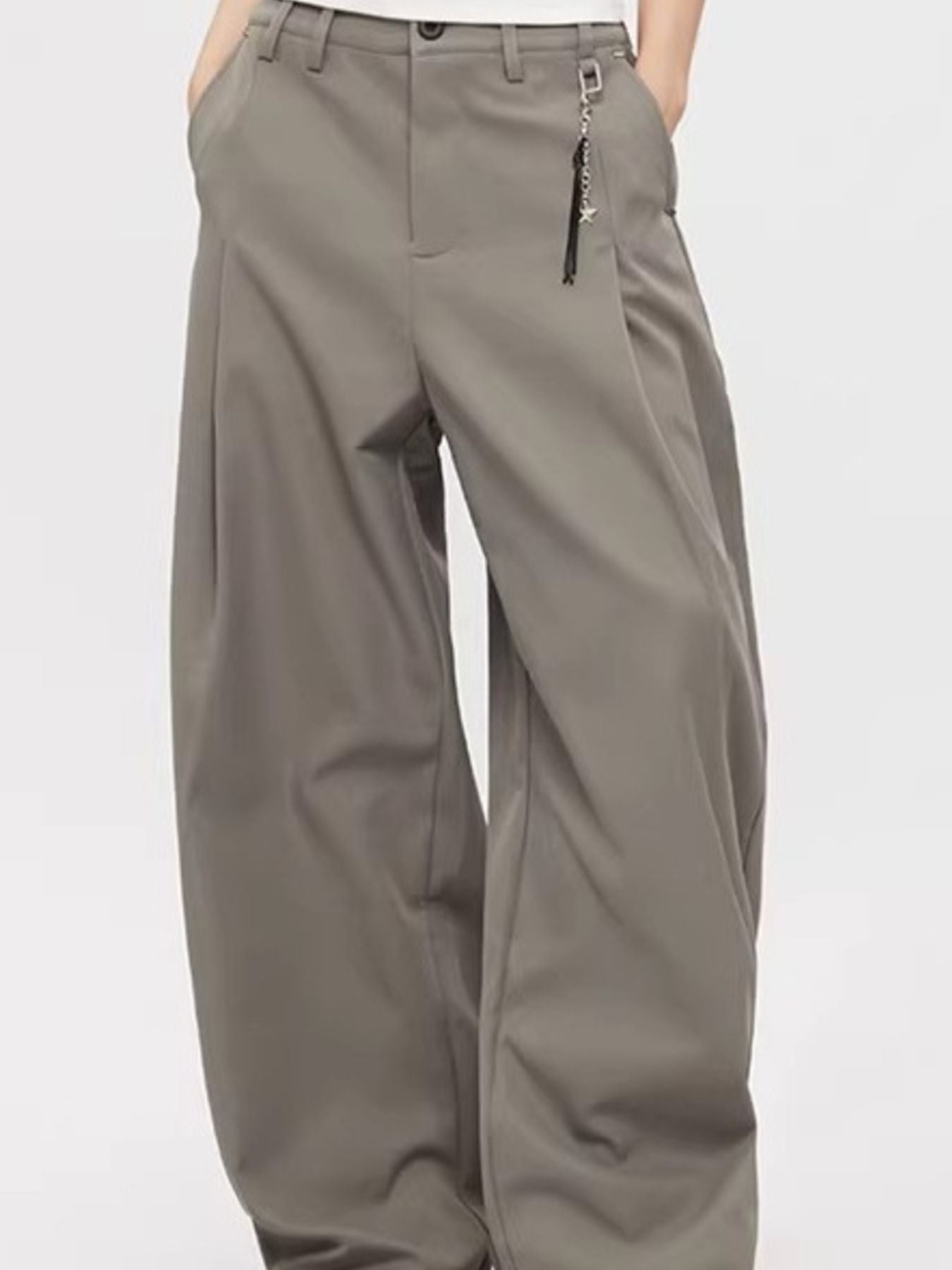 Men's grey high-waisted wide leg sweatpants with button closure and charm detail.