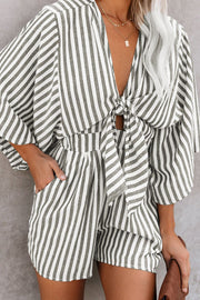 Striped tie-front kimono jumpsuit in dark gray with wide sleeves and a tie detail.