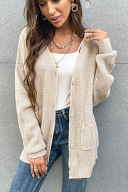 Beige waffle knit cardigan with buttons and pockets, styled casually.