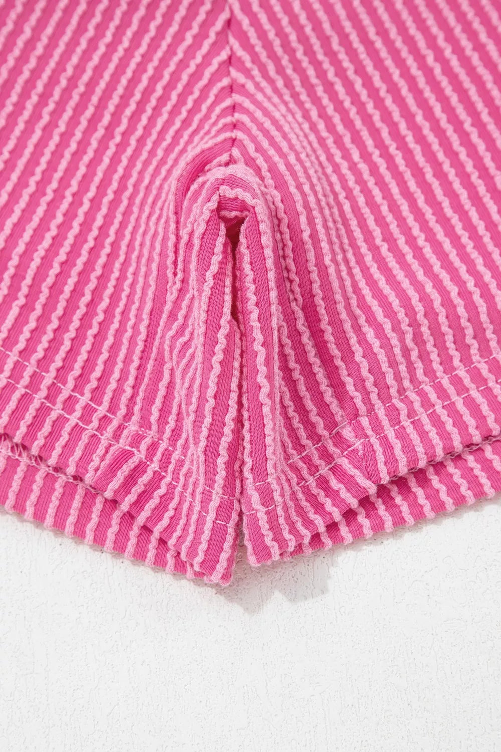 Pink ribbed pajama shorts with contrasting stripe detail and side slits.