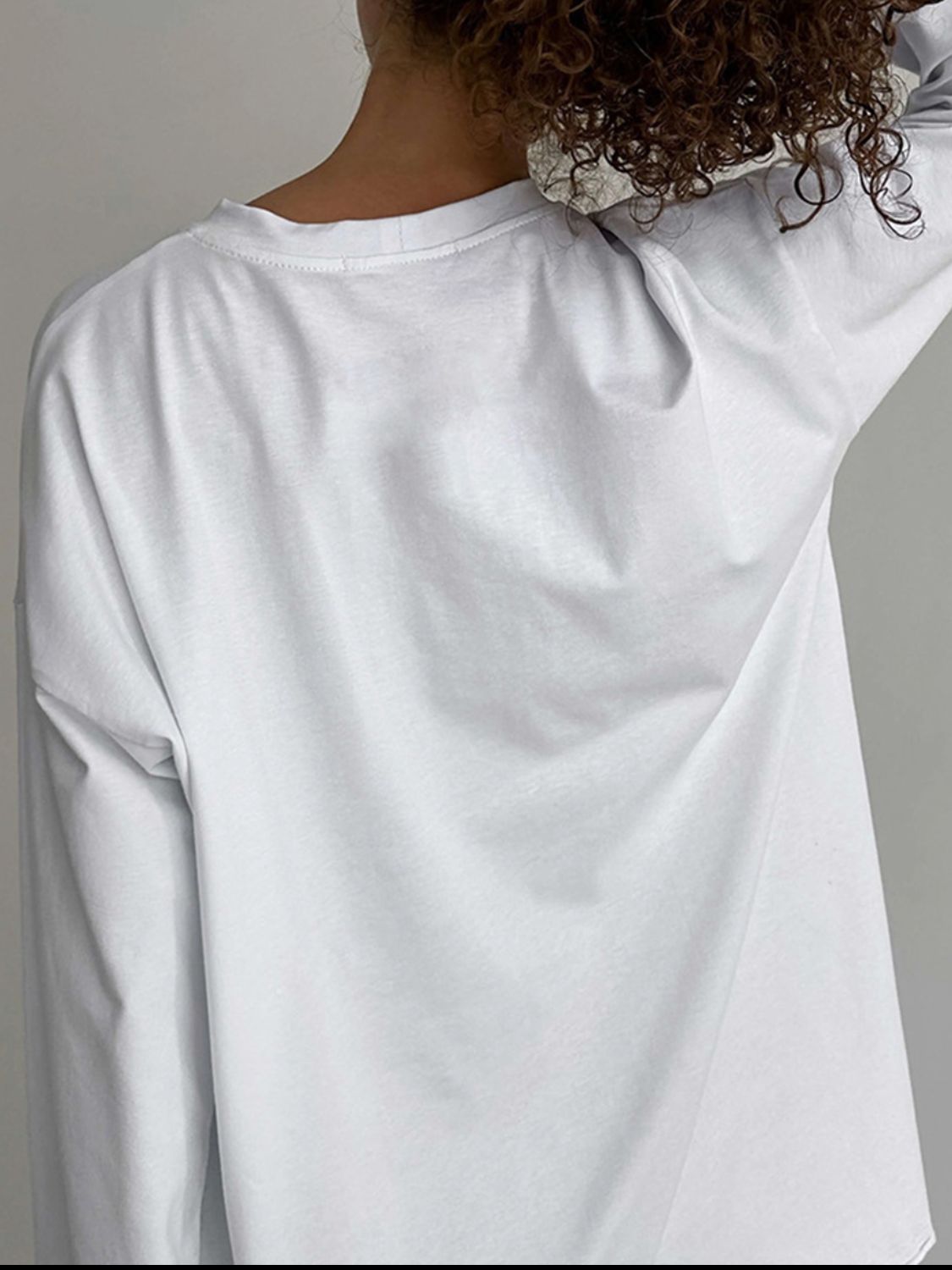 Oversized white cotton jersey long sleeve top with crew neck, shown from the back.