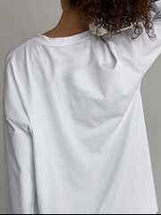Oversized white cotton jersey long sleeve top with crew neck, shown from the back.