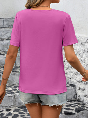 Fuchsia pink jersey top with puffed short sleeves and a crew neck.