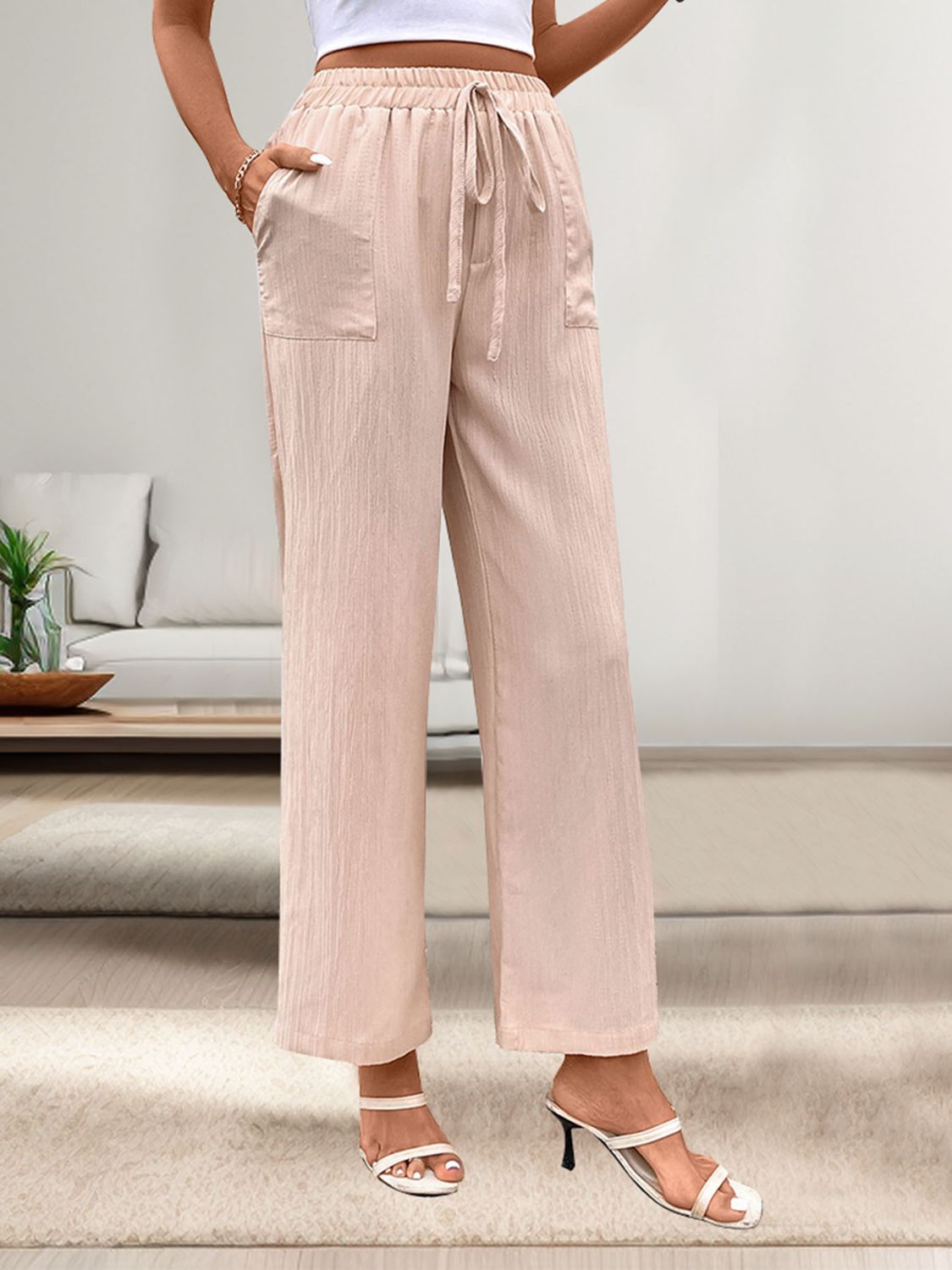 Apricot linen palazzo pants with drawstring waist and patch pockets.