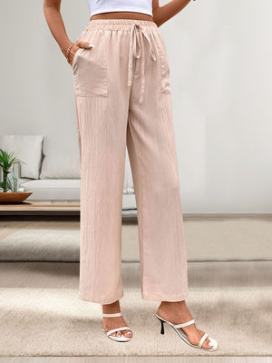 Apricot linen palazzo pants with drawstring waist and patch pockets.