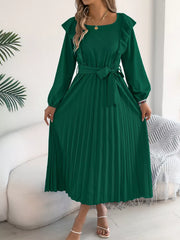Green A-line midi dress with ruffles, long sleeves, and pleated skirt.