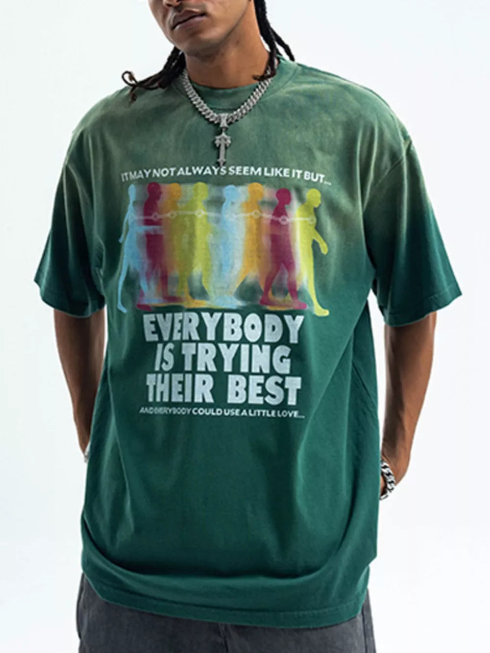 Green acid wash graphic t-shirt with crew neck and short sleeves, featuring text and colorful figures.