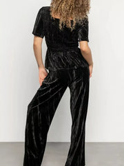Black velvet two-piece set with flutter sleeves and wide-leg pants.