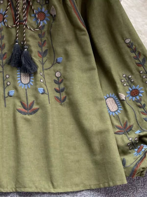 Green tie neck blouse with intricate floral embroidery and tassel detail