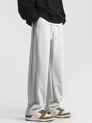 Gray sweatpants with a loose fit, drawstring waist, and subtle side stripe detail.