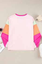 Colorblock long sleeve t-shirt in blush pink with colorblocked sleeves in green, orange, and pink.