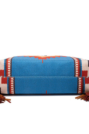 Southwestern fringe hobo bag in blue canvas with geometric pattern and leather fringe details.