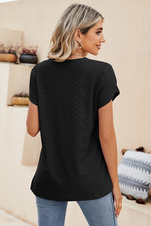 Black knit top with perforated sleeve detail and textured pattern