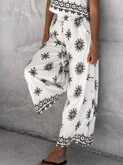 White two-piece set with black medallion print, drawstring waist pants and cropped top.