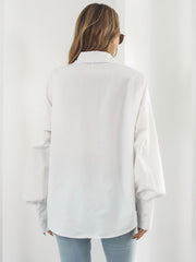 White poplin oversized blouse with blouson sleeves and buttoned cuffs.