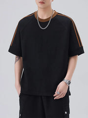 Black oversized t-shirt with brown contrast stitching on sleeves and neckline.