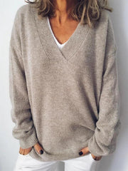 Relaxed V-neck ribbed knit sweater in tan acrylic, styled casually with white pants.