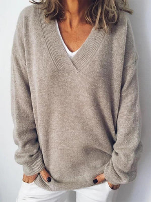 Relaxed V-neck ribbed knit sweater in tan acrylic, styled casually with white pants.