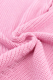 Relaxed knit V-neck pullover in blush pink acrylic with a textured knit pattern.