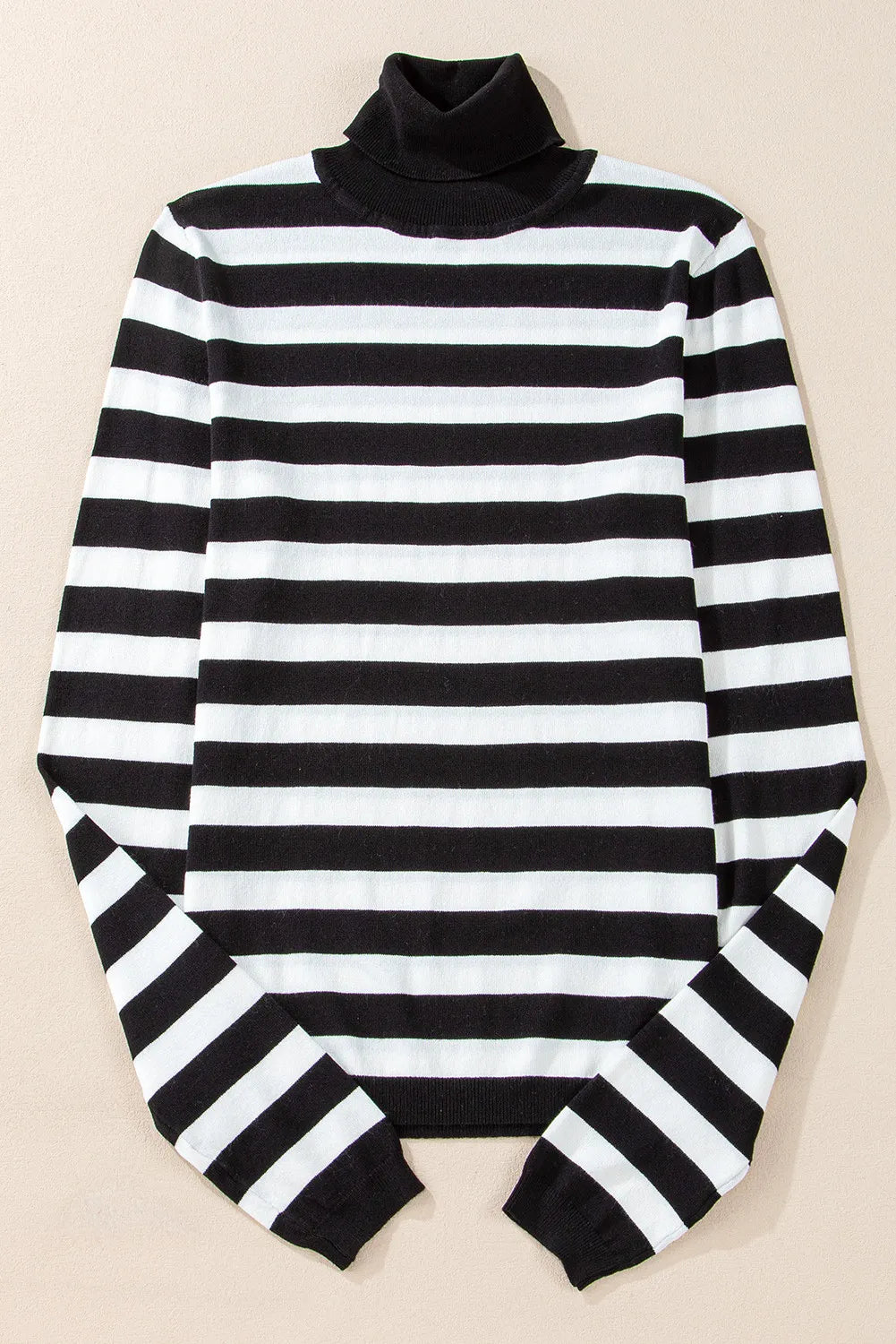 Graphic ribbed turtleneck sweater in black and white stripes.