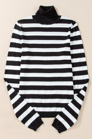 Graphic ribbed turtleneck sweater in black and white stripes.