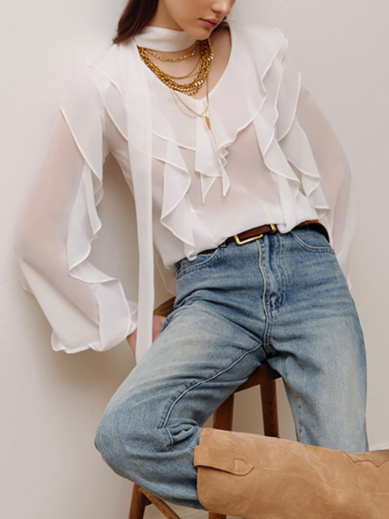 White chiffon blouse with ruffle trim and V-neck, featuring sheer bell sleeves.