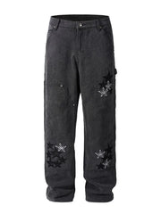 Dark wash carpenter jeans with embroidered stars and checkered pattern details.