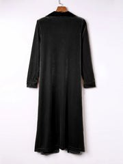 Black velvet duster coat with fluid silhouette, long sleeves and notched collar.