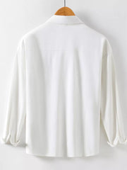 White cotton long sleeve button-up shirt with collar and rolled cuffs.