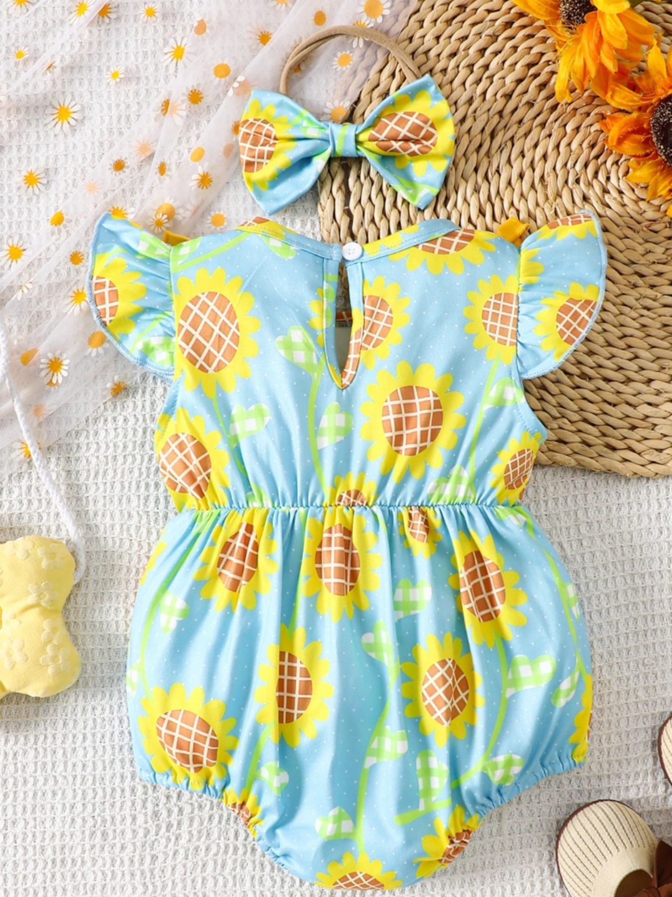 Baby girl's pastel blue sunflower print cotton romper with ruffle sleeves and matching bow headband.
