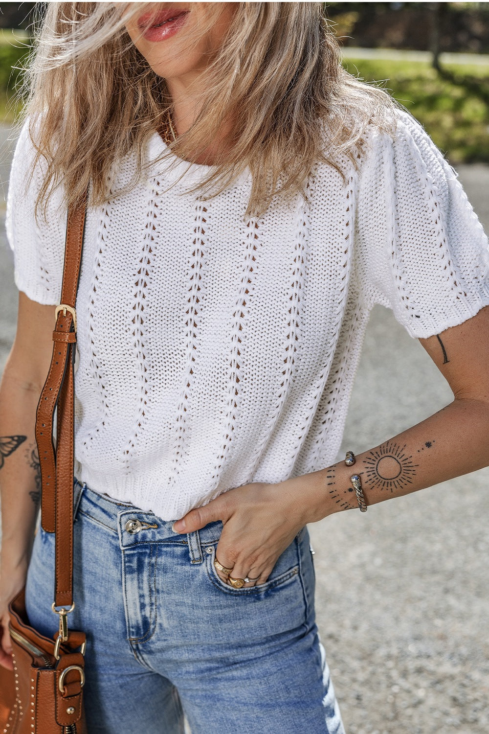 White eyelet knit puff sleeve top with a textured pattern.