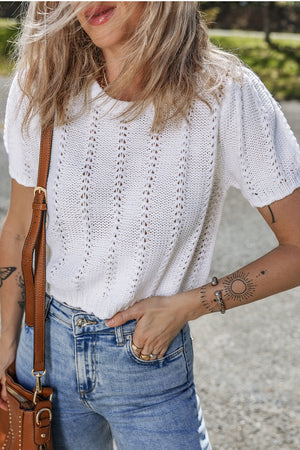 White eyelet knit puff sleeve top with a textured pattern.