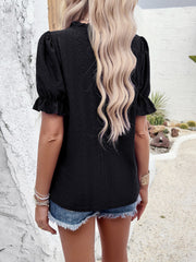 Black eyelet puff sleeve blouse with ruffled cuffs and neckline