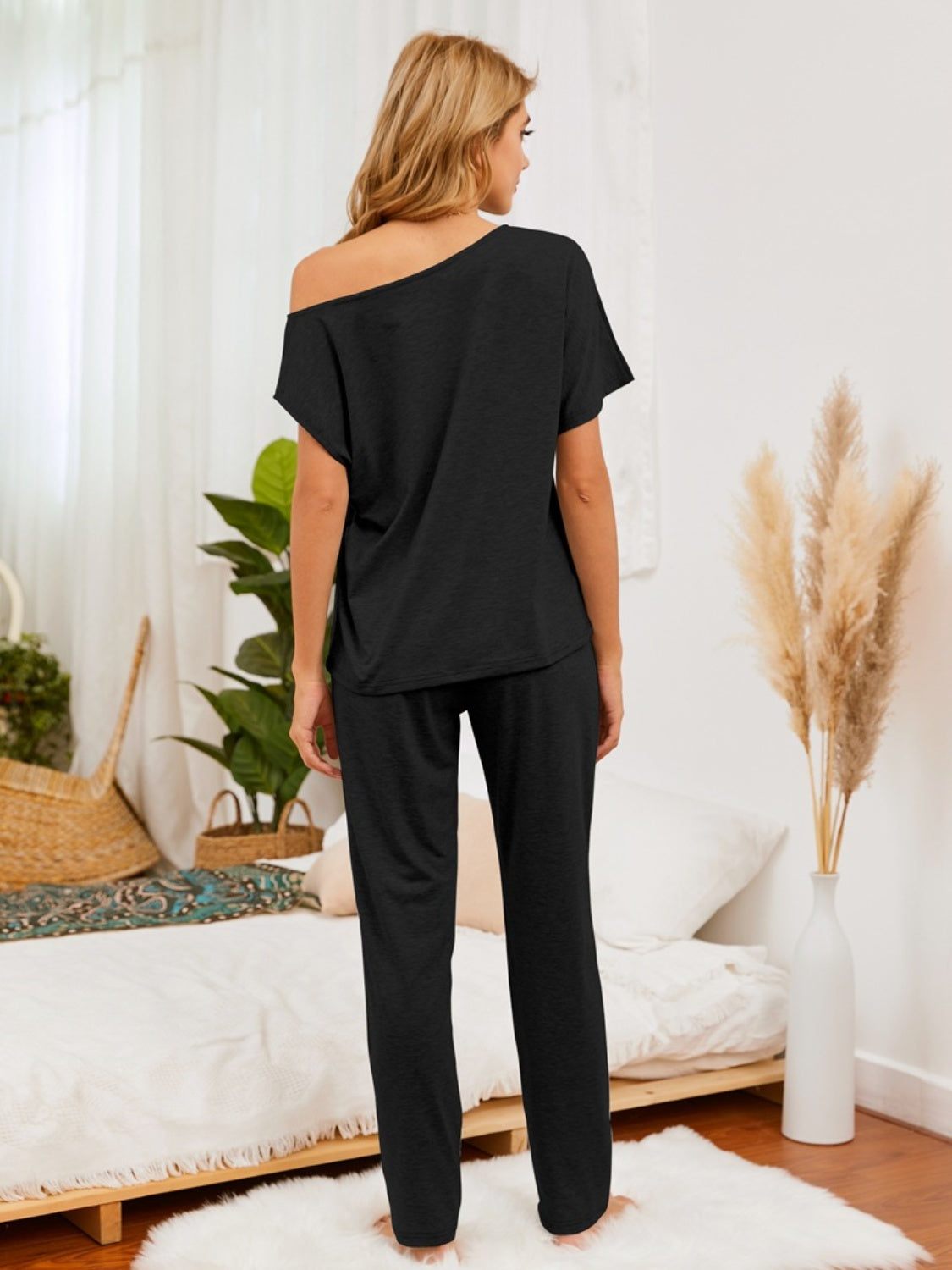 Black asymmetric shoulder lounge set with relaxed fit pants.