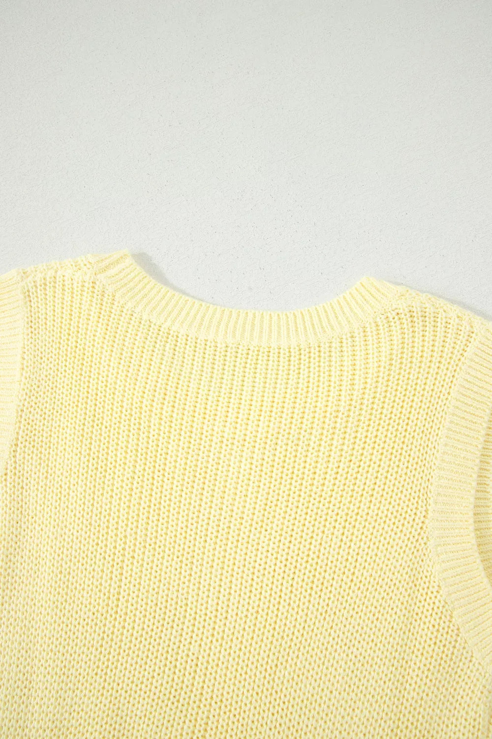 Yellow knit sweater vest with crewneck and ribbed trim.