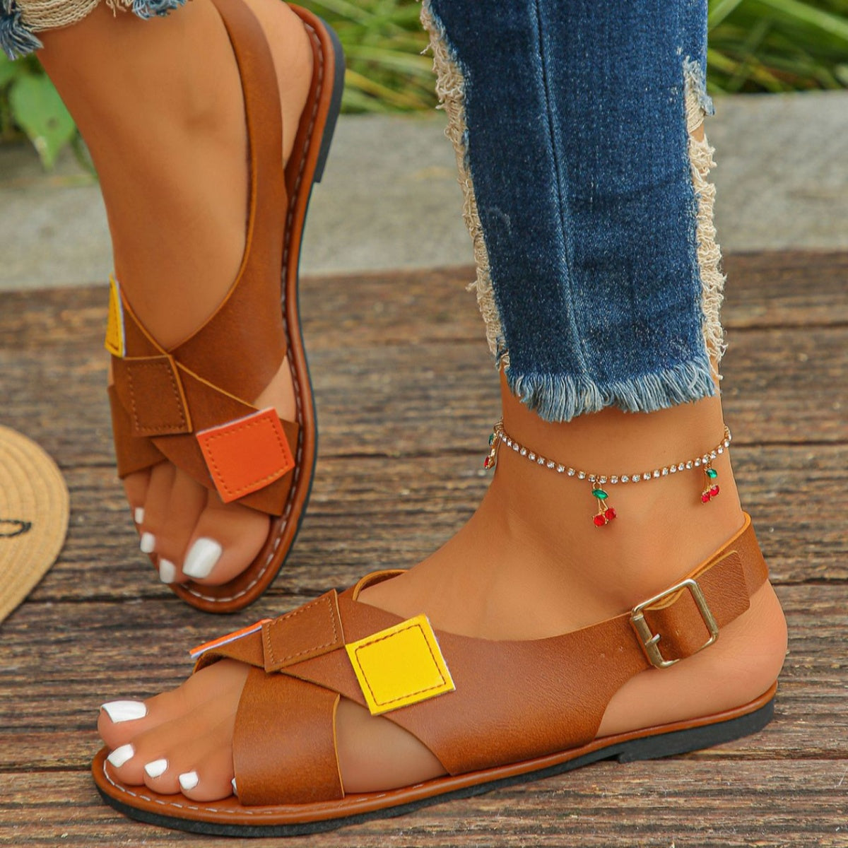 Brown patchwork ankle strap sandals with criss-cross straps and colorful square accents.