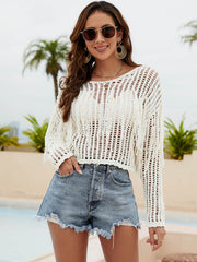 Cream open-knit crop sweater with fringe details and long sleeves.