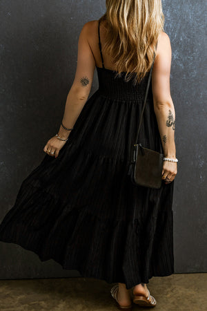 Black tiered maxi dress with smocked bodice and textured fabric.