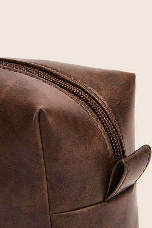 Textured faux leather travel case in caramel with a zipper and pull tab.