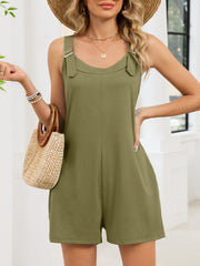 Army green buckle strap pocketed romper with V-neck and tie straps, styled with a straw hat and bag.