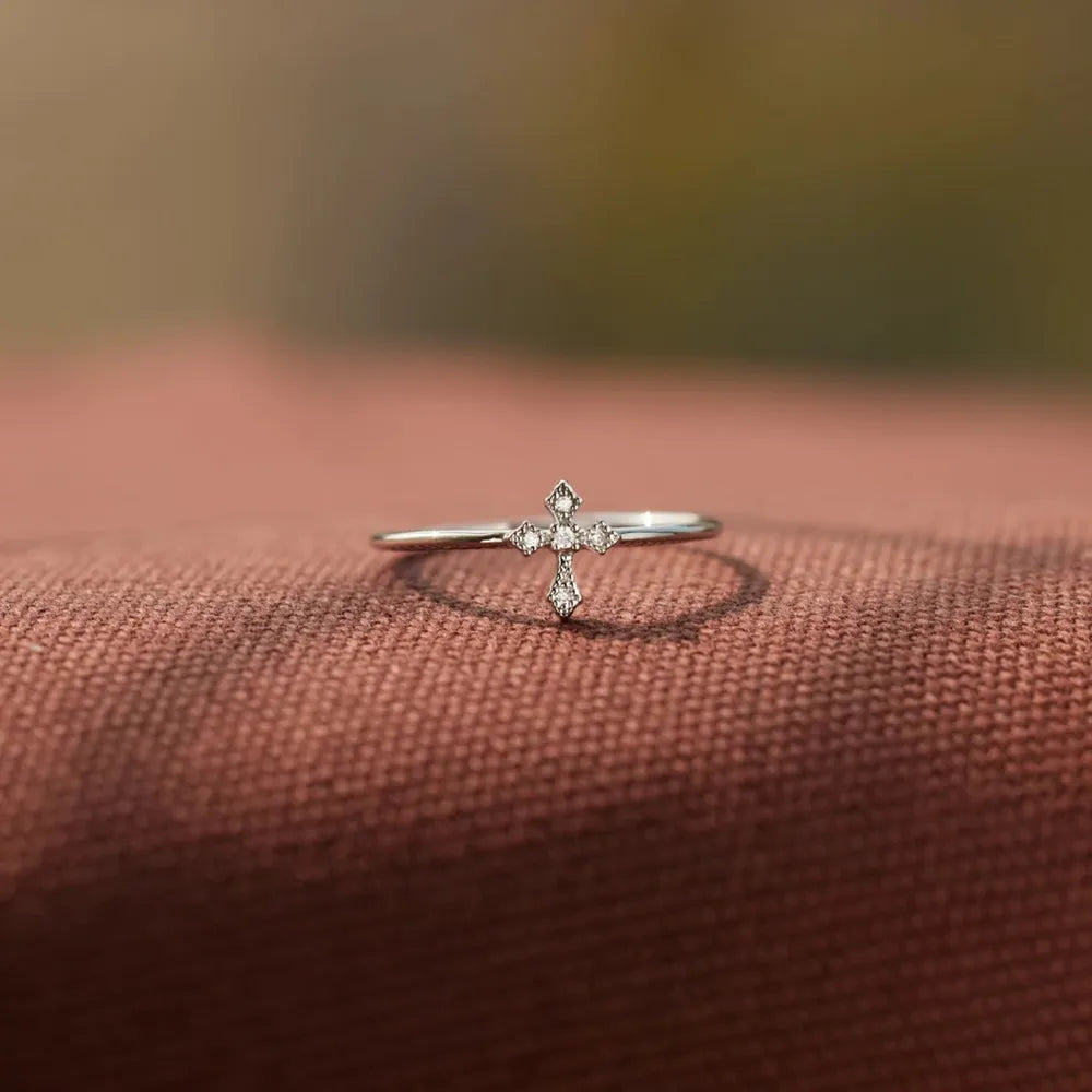 Delicate diamond cross ring in silver with sparkling stones.