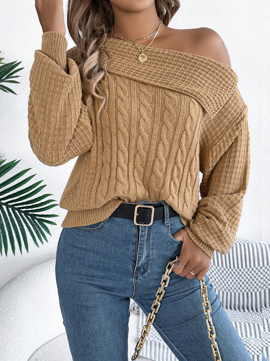 Camel off-shoulder cable knit pullover sweater with asymmetrical neckline and wide sleeves.