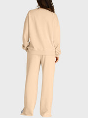 Tan loungewear set with crewneck sweatshirt and wide-leg trousers with slit-front detail.