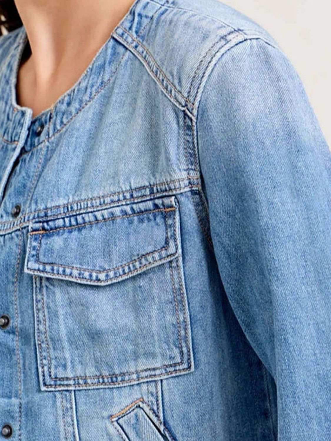 Light wash denim utility jacket with band collar and chest cargo pocket.